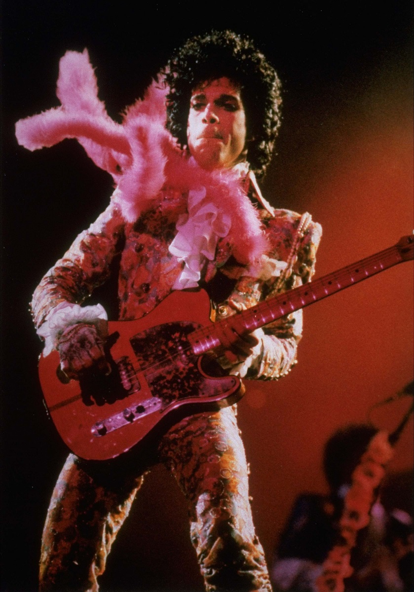Purple Rain star Prince performs in concert at the Summit Thursday night, Jan. 11, 1985 before a sold-out audience, his first of six Houston shows. A purple feather boa blows in the wind from a fan. (AP Photo/F. Carter Smith)