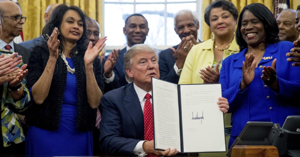 President Donald Trump holds up the Historically Black Colleges and Universities HBCU Executive Order after signing it, Tuesday, Feb. 28, 2017, in the Oval Office in the White House in Washington. (AP Photo/Andrew Harnik)