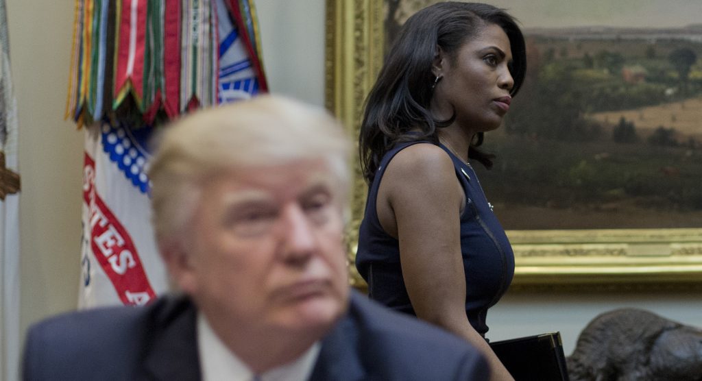 White House Director of communications for the Office of Public Liaison Omarosa Manigault, right, walks past President Donald Trump during a meeting on healthcare in the Roosevelt Room of the White House in Washington, Monday, March 13, 2017. (AP Photo/Pablo Martinez Monsivais)