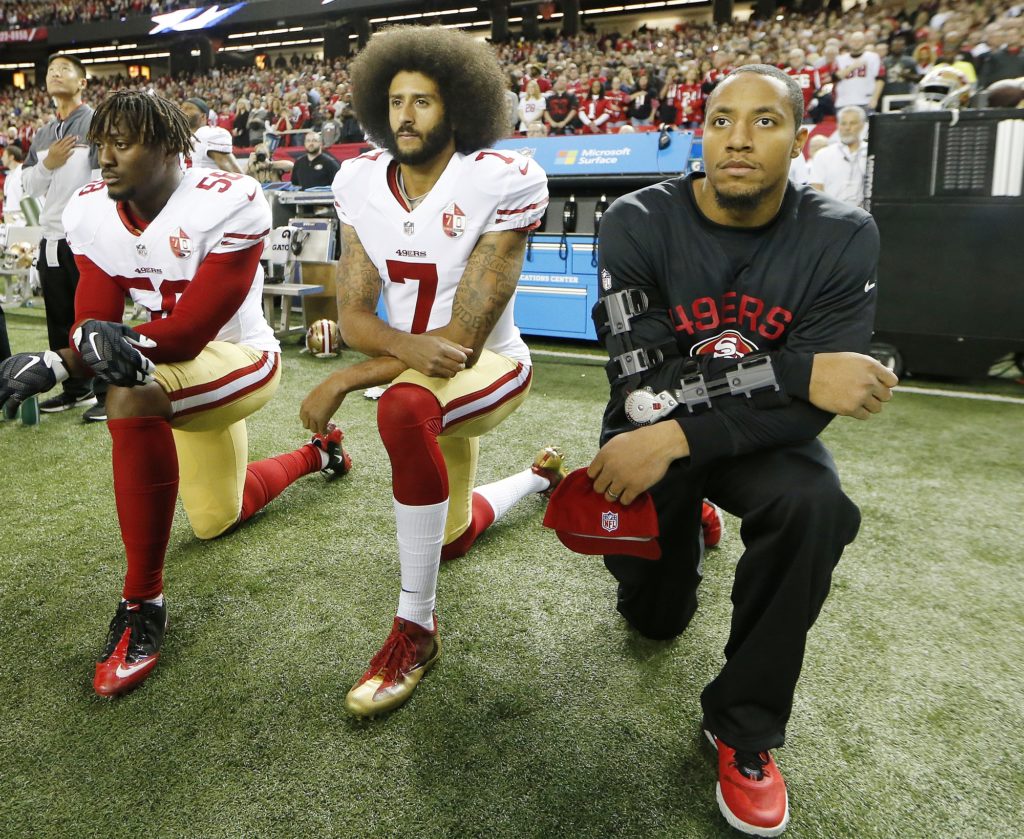 San Francisco 49ers quarterback Colin Kaepernick (7) and San Francisco 49ers outside linebacker Eli Harold (58) kneel during the playing of the National anthem before the first half of an NFL football game between the Atlanta Falcons and the San Francisco 49ers, Sunday, Dec. 18, 2016, in Atlanta. (AP Photo/John Bazemore)
