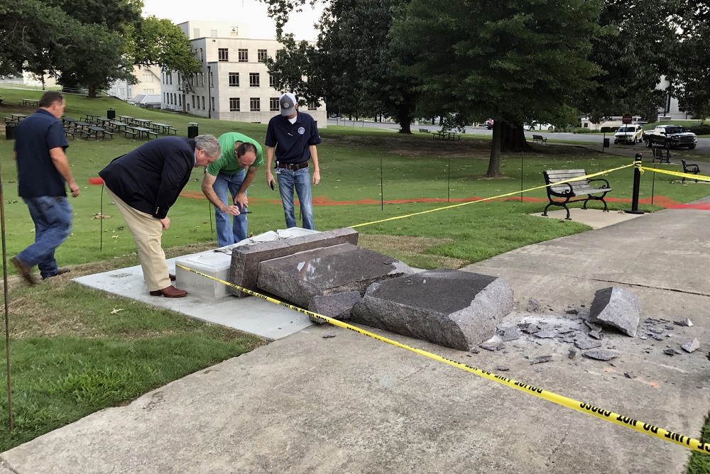 Personnel from the Secretary of State's office inspect the damage to the new Ten Commandments monument outside the state Capitol in Little Rock, Ark., Wednesday morning, June 28, 2017, after someone crashed into it with a vehicle, less than 24 hours after the privately funded monument was installed on the Capitol grounds. Authorities arrested a male suspect. (AP Photo/Jill Zeman Bleed)