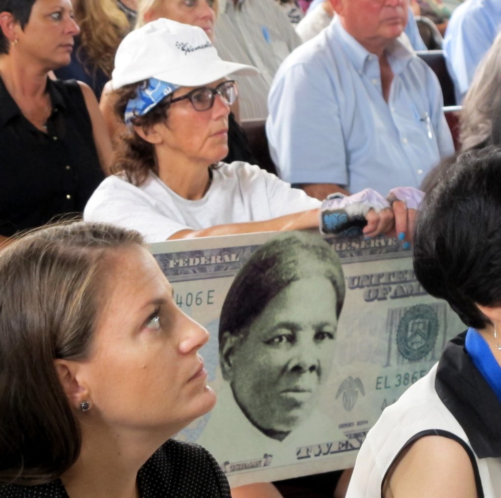 FILE - In this Monday, Aug. 31, 2015, file photo, a woman holds a sign supporting Harriet Tubman for the $20 bill during a town hall meeting at the Women's Rights National Historical Park in Seneca Falls, N.Y. A Treasury official said Wednesday, April 20, 2016, that Secretary Jacob Lew has decided to put Harriet Tubman on the $20 bill, making her the first woman on U.S. paper currency in 100 years. (AP Photo/Carolyn Thompson, File)