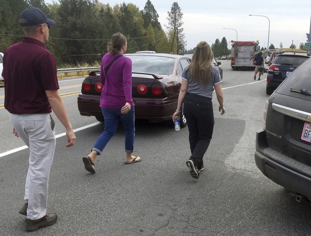 People hurry toward Freeman High School in Rockford, Wash., Wednesday, Sept. 13, 2017. Parents rushed to the area after a deadly shooting at the school. (AP Photo/Nicholas K. Geranios)
