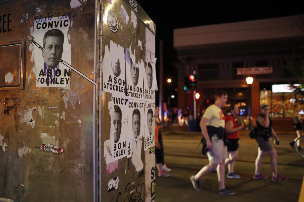 People march past images of former St. Louis police officer Jason Stockley after a not guilty verdict in his trial Saturday, Sept. 16, 2017, in St. Louis. Stockley was acquitted in the 2011 killing of a black man following a high-speed chase. (AP Photo/Jeff Roberson)