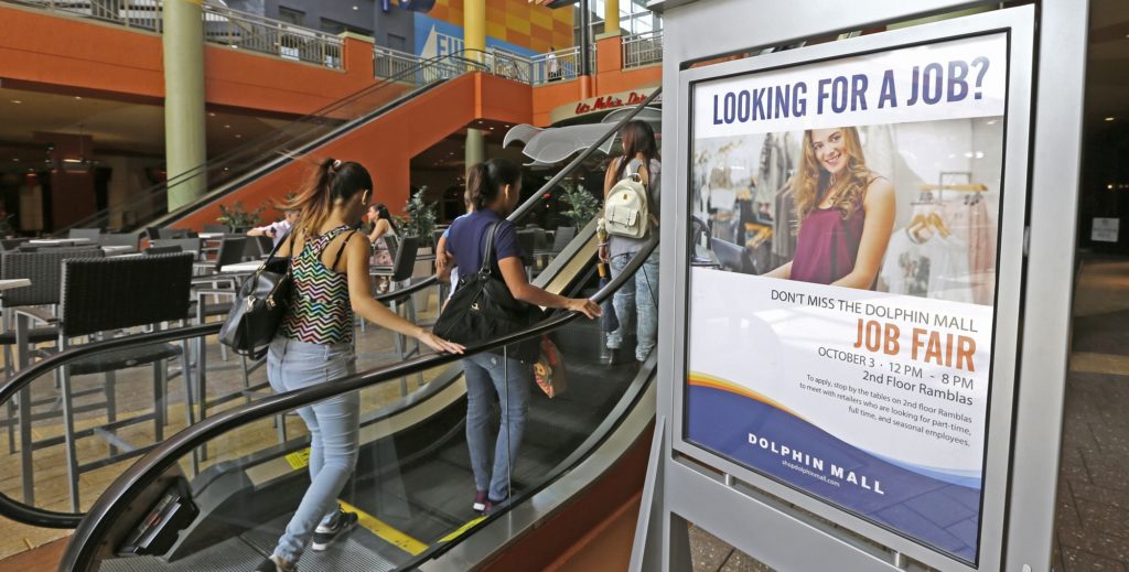 In this Tuesday, Oct. 3, 2017, photo, people head to at a job fair at Dolphin Mall in Sweetwater, Fla. The shopping center hosted a job fair in preparation for the approaching busy holiday retail season. On Thursday, Oct. 5, 2017, the Labor Department reports on the number of people who applied for unemployment benefits a week earlier. (AP Photo/Alan Diaz)