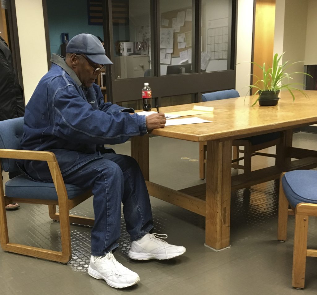 Former football legend O.J. Simpson signs documents at the Lovelock Correctional Center, Saturday, Sept. 30, 2017, in Lovelock, Nev. Simpson was released from the Lovelock Correctional Center in northern Nevada early Sunday, Oct. 1, 2017. (Brooke Keast/Nevada Department of Corrections via AP)