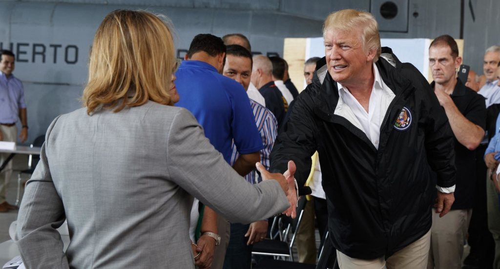 President Donald Trump shakes hands with San Juan Mayor Carmen Yulin Cruz during a briefing on hurricane recovery efforts with first responders at Luis Muniz Air National Guard Base, Tuesday, Oct. 3, 2017, in San Juan, Puerto Rico. (AP Photo/Evan Vucci)