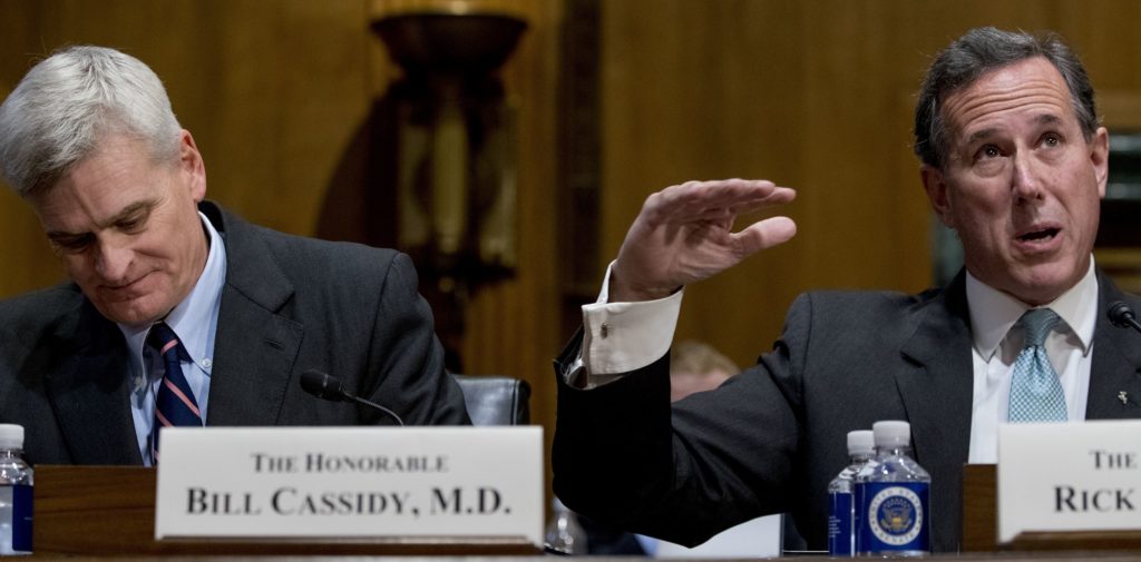 Former Pennsylvania Sen. Rick Santorum, right, accompanied by Sen. Bill Cassidy, R-La., left, speaks during a Senate Finance Committee hearing to consider the Graham-Cassidy healthcare proposal, on Capitol Hill, Monday, Sept. 25, 2017, in Washington. (AP Photo/Andrew Harnik)
