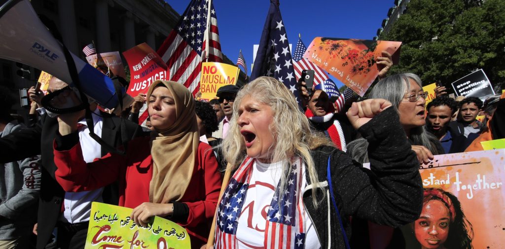 Ivania Castillo, right, and Abrar Omeish, left, of Libya descent, join a march of Muslim and civil rights groups and their supporters, against what they call a "Muslim ban" near the White House in Washington, Wednesday, Oct. 18, 2017. (AP Photo/Manuel Balce Ceneta)