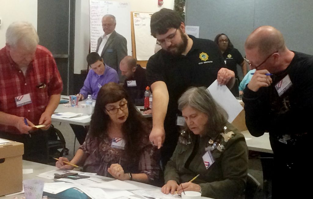 Election officials in Newport News, Va., examine ballots that a computer failed to scan during a recount for a House of Delegates race on Tuesday, Dec. 19, 2017. Republican incumbent Del. David Yancey had won against Democratic challenger Shelly Simonds by just 10 votes in November. (AP Photo/Ben Finley)