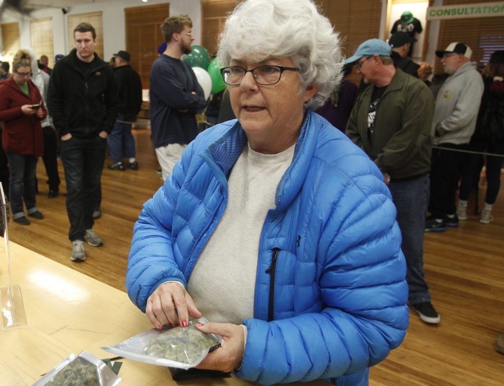 Margot Simpson, right, purchases marijuana at Harborside marijuana dispensary, Monday, Jan. 1, 2018, in Oakland, Calif. Starting New Year's Day, recreational marijuana can be sold legally in California. (AP Photo/Mathew Sumner)