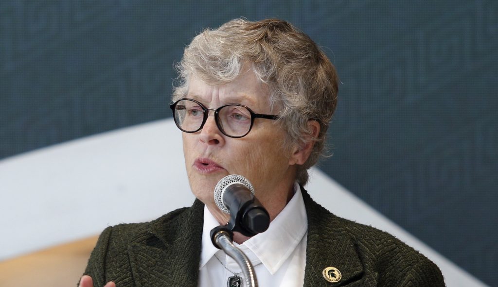 In this Oct. 20, 2017, photo, Michigan State University President Lou Anna Simon speaks during the dedication ceremony for the Gilbert Pavilion and Tom Izzo Hall of History inside Michigan State's Breslin Student Events Center in East Lansing, Mich. Simon submitted her resignation Wednesday, Jan. 24, 2018, amid an outcry over the school's handling of allegations against Larry Nassar. (AP Photo/Al Goldis, File)
