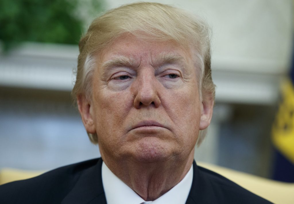 President Donald Trump listens during a meeting with North Korean defectors where he talked with reporters about allowing the release of a secret memo on the F.B.I.'s role in the Russia inquiry, in the Oval Office of the White House, Friday, Feb. 2, 2018, in Washington. (AP Photo/Evan Vucci)