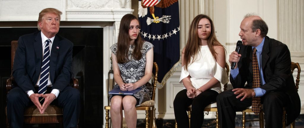 From left, President Donald Trump, Marjory Stoneman Douglas High School student students Carson Abt, and Ariana Klein, listen as Carson's father Frederick Abt, speaks during a listening session with high school students, teachers, and others in the State Dining Room of the White House in Washington, Wednesday, Feb. 21, 2018. In the aftermath of yet another mass school shooting, Trump says that if one of the victims, a football coach, had been armed “he would have shot and that would have been the end of it.” Revisiting an idea he raised in his campaign, Trump’s comments in favor of allowing teachers to be armed come as lawmakers in several states are wrestling with the idea, including in Florida, where the 17 most recent school shooting victims are being mourned.(AP Photo/Carolyn Kaster)