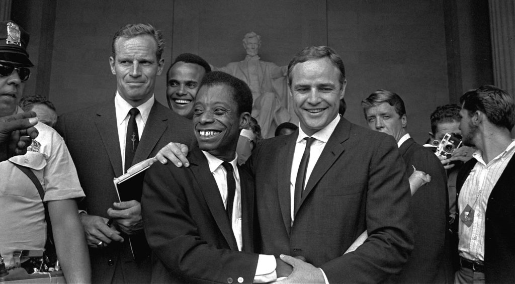 Actor Marlon Brando, right, poses with his arm around James Baldwin, author and civil rights leader, in front of the Lincoln statue at the Lincoln Memorial, August 28, 1963, during the March on Washington demonstration ceremonies which followed the mass parade. Posing with them are actors Charlton Heston, left, and Harry Belafonte. (AP Photo)
