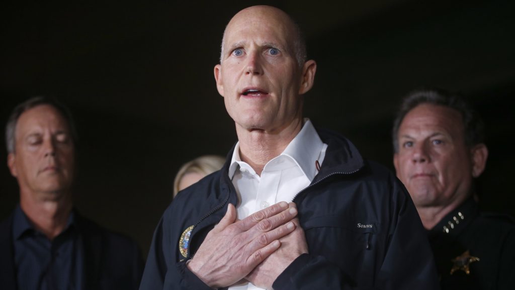 Florida Gov. Rick Scott gestures as he speaks during a news conference near Marjory Stoneman Douglas High School in Parkland, Fla., where a former student is suspected of killing at least 17 people Wednesday, Feb. 14, 2018. The shooting at a South Florida high school sent students rushing into the streets as SWAT team members swarmed in and locked down the building. Police were warning that the shooter was still at large even as ambulances converged on the scene and emergency workers appeared to be treating those possibly wounded. (AP Photo/Wilfredo Lee)