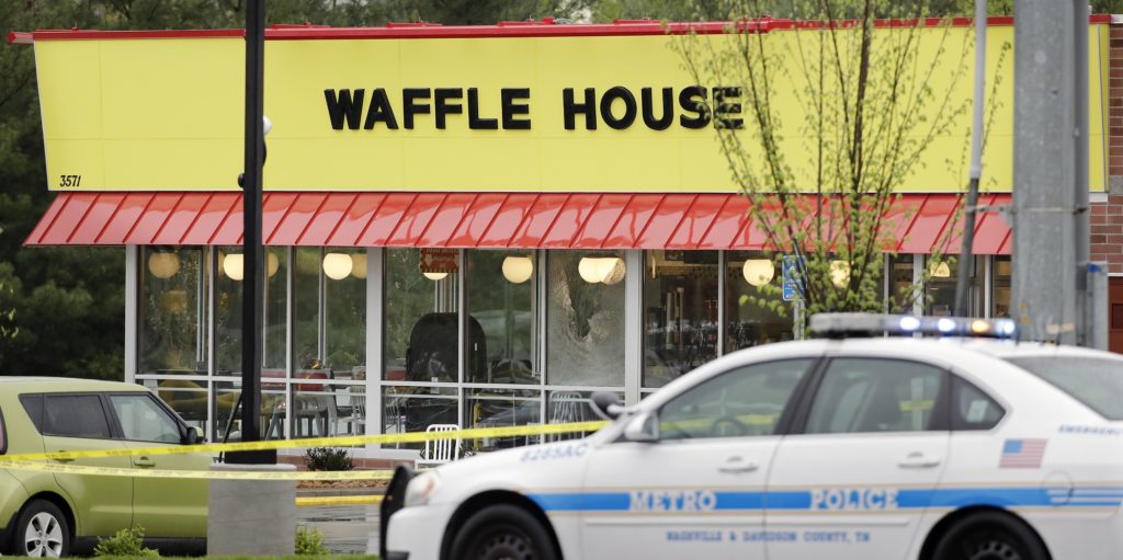 A police car sits in front of a Waffle House restaurant Sunday, April 22, 2018, in Nashville, Tenn. At least four people died after a gunman opened fire at the restaurant early Sunday. (AP Photo/Mark Humphrey)