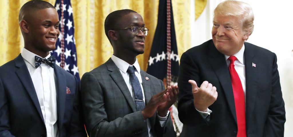 President Donald Trump, right, gestures toward brothers Cam'eron Hill, and Christian Hill, left, during an event about taxes, Friday, June 29, 2018, in the East Room of the White House in Washington. (AP Photo/Jacquelyn Martin)