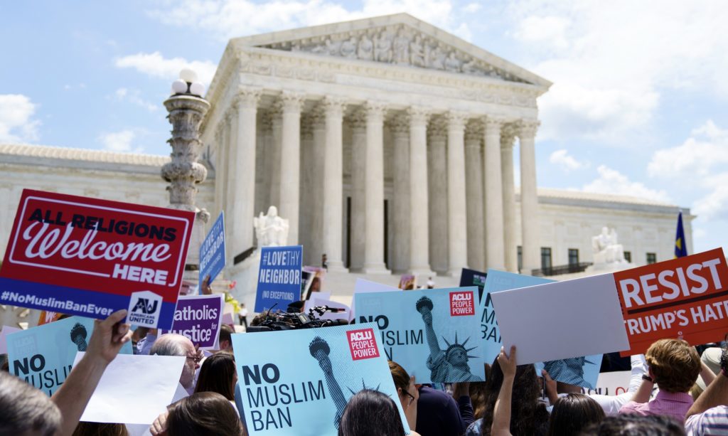Protesters hold up signs and call out against the Supreme Court ruling upholding President Donald Trump's travel ban outside the the Supreme Court in Washington, Tuesday, June 26, 2018. (AP Photo/Carolyn Kaster)
