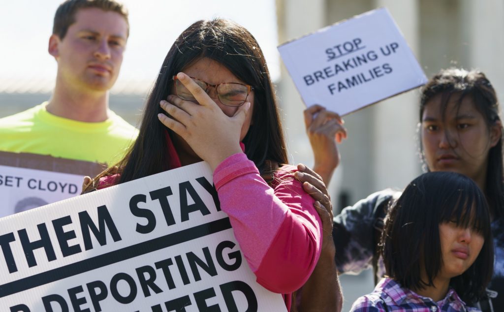 Caitlin Sanger, of Franklin Park, N.J., pauses to cry outside the Supreme Court in Washington, Tuesday, June 26, 2018, as she speaks about her father being detained by ICE and protests immigrant families being split up. Naomi Liem, 10, of Franklin Park, N.J., cries lower right and Jocelyn Pangemanan of Highland Park, N.J., stands right. (AP Photo/Carolyn Kaster)