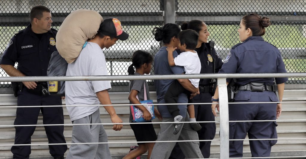 Ever Castillo, left, and his family, immigrants from Honduras, are escorted back across the border by U.S. Customs and Border Patrol agents Thursday, June 21, 2018, in Hildalgo, Texas. The parents were told they would be separated from their children and voluntarily crossed back to Mexico after trying to seek asylum in the United States. (AP Photo/David J. Phillip)