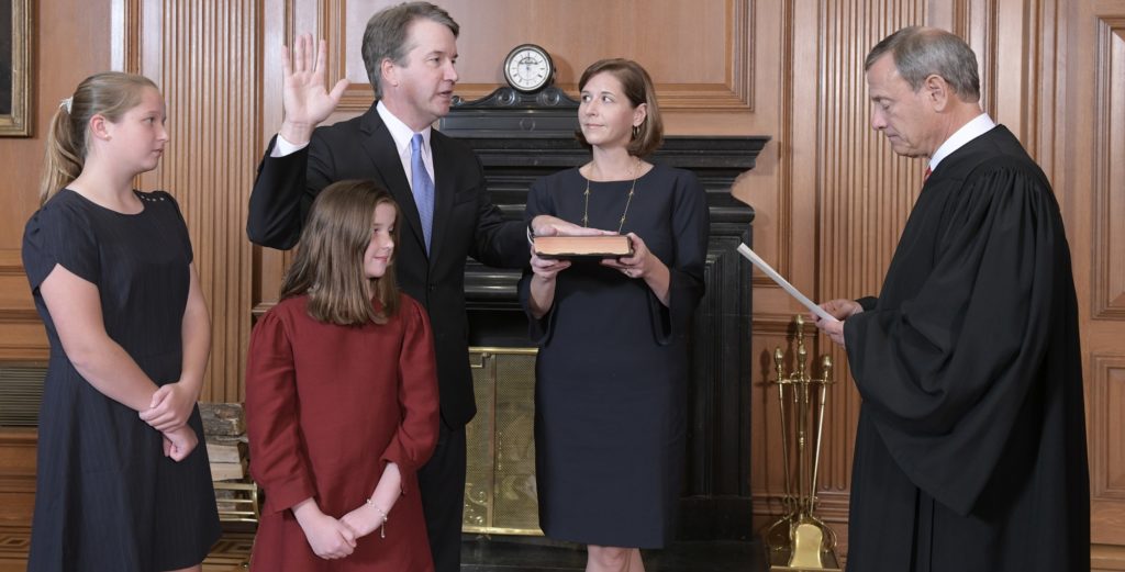 Chief Justice John Roberts, right, administers the Constitutional Oath to Judge Brett Kavanaugh in the Justices' Conference Room of the Supreme Court Building. Ashley Kavanaugh holds the Bible. In the foreground are their daughters, Margaret, left, and Liza. (Fred Schilling/Collection of the Supreme Court of the United States via AP)