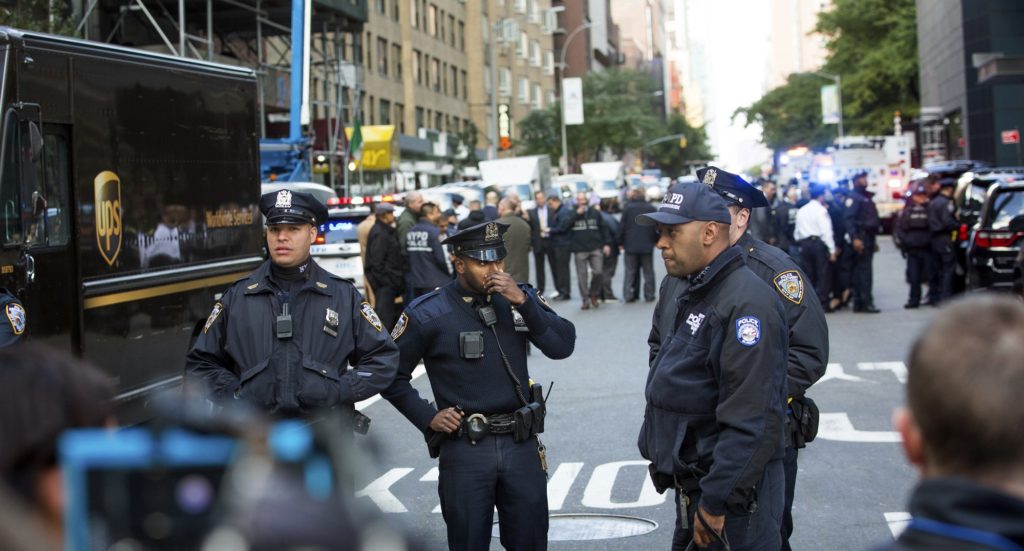 Officers watch over the scene outside the Time Warner Center on Wednesday, Oct. 24, 2018, in New York. Law enforcement officials say a suspicious package that prompted an evacuation of CNN's offices is believed to contain a pipe bomb. (AP Photo/Kevin Hagen)