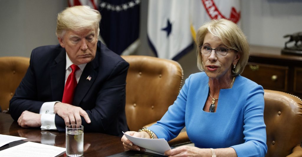 President Donald Trump listens as Secretary of Education Betsy DeVos speaks during a roundtable discussion on the Federal Commission on School Safety report, in the Roosevelt Room of the White House, Tuesday, Dec. 18, 2018, in Washington. (AP Photo/Evan Vucci)