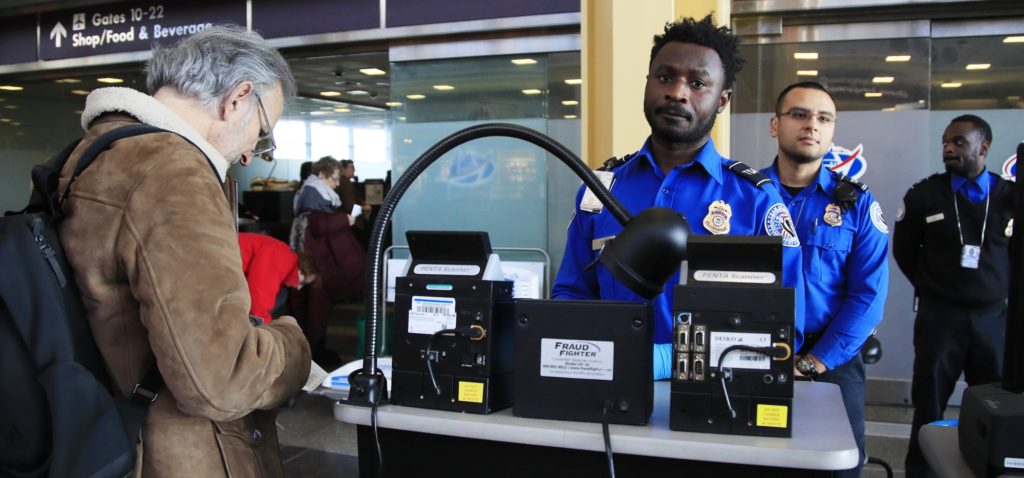 Transportation Security Administration (TSA) officers check and watch airline passengers at Reagan National Airport in Washington, Thursday, Dec. 27, 2018. TSA employees are working through the partial government shutdown without pay. There is no end in sight to the partial government shutdown. President Donald Trump has vowed to hold the line on his budget demand, telling reporters during his visit to Iraq Wednesday that he'll do "whatever it takes" to get money for border security. The White House and congressional Democrats have been talking but to little effect. (AP Photo/Manuel Balce Ceneta)