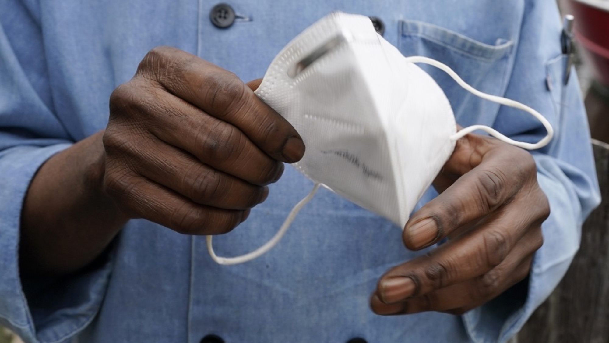 FILE - In this Friday, March 5, 2021 file photo, a restaurant worker holds his face mask in Biloxi, Miss. On Friday, March 12, 2021, The Associated Press reported on stories circulating online incorrectly asserting a new study from the U.S. Centers for Disease Control and Prevention found that mask mandates have a negligible impact on coronavirus numbers. Those claims distort the findings, according to CDC scientist Gery Guy Jr., the study's lead author. “Each day that growth rate is going down, the cumulative effect — in terms of cases and deaths — adds up to be quite substantial,” Guy told the AP in a previous report. (AP Photo/Rogelio V. Solis)